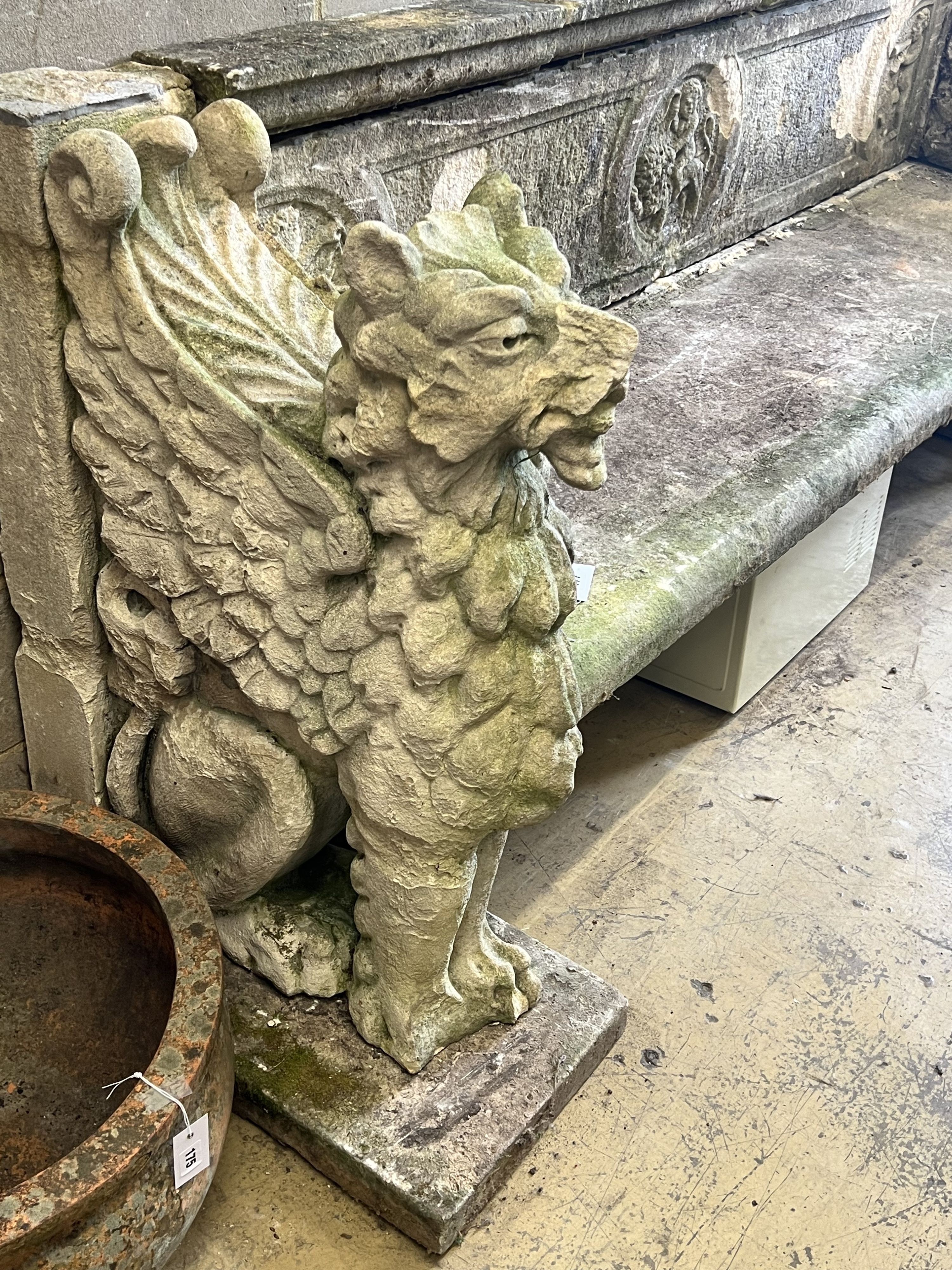 A monumental reconstituted stone winged lion or griffin garden bench, width 250cm depth 66cm height 96cm, in need of restoration